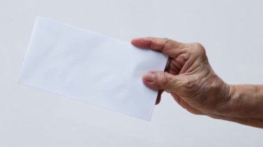 Beyaz arka planda izole edilmiş beyaz zarf ya da gelinin sağ eli, yakın çekim ve makro çekim, iş konsepti