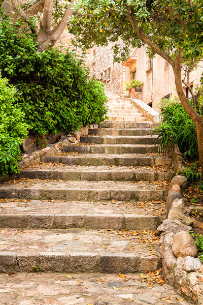 Stairs in S-curve shape in old historic street of Tossa de Mar, Costa Brava, Catalonia, Spain. Late summer photo.