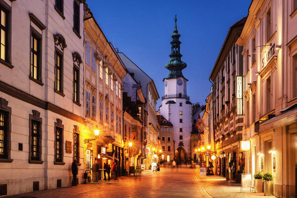 17. february 2015 - Bratislava, Slovakia: evening illumination of old street in historic center of Bratislava with famous tower called 