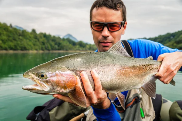 Pescador con captura de trucha arco iris, Eslovenia — Foto de Stock