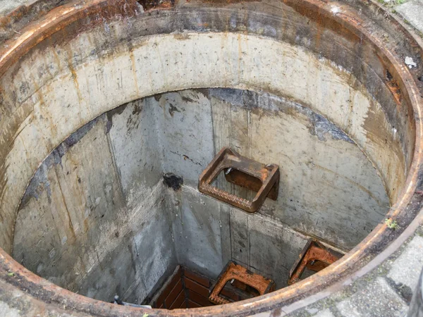 Cast crampons in a open Sewer — Stok fotoğraf