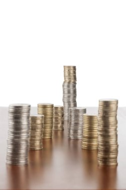 Düz açılı, pürüzsüz ahşap zemin üzerine istiflenmiş avro sikkeleri manzarası. Dördüncü satıra odaklan.