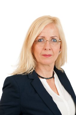 Sarışın, uzun saçlı, siyah ceketli orta yaşlı bir kadının omuz omuza portresi. Beyaz bir arkaplanda kameraya bakıyor..