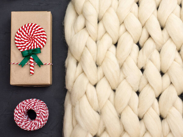 Уютная композиция, одеяло из мериносовой шерсти крупным планом, теплая и уютная атмосфера. Фон вязания. Завернутые подарки. Концепция Рождества
.