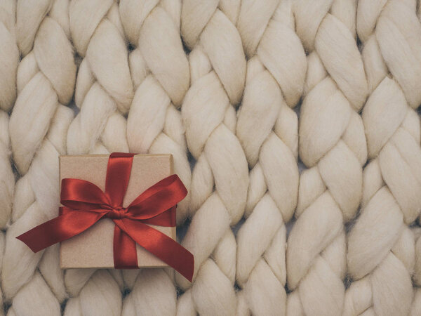 Wrapped vintage gift box. Copy space. Holiday concept. Merino wool blanket. Knit background.