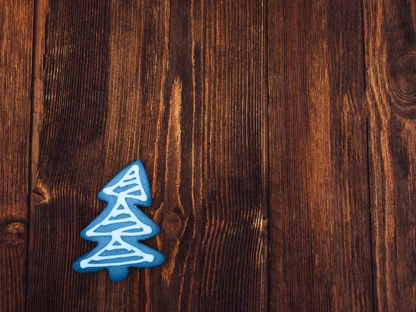 Blauer Weihnachtskeks wie Tanne auf Holz-Hintergrund. — Stockfoto