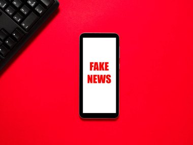 Kırmızı arkaplanda Sahte Metin Haberleri.