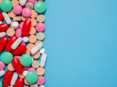 Renkli, yeşil, kırmızı, beyaz haplar mavi arka planda, düz yerde