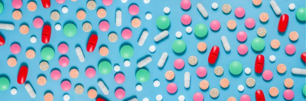 Colorful, green, red, white pills on blue background, flat lay — Stock Photo, Image