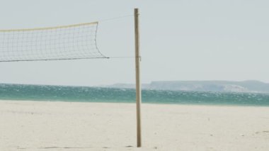 Ağır çekimde rüzgarlı bir günde sahilde Voleybol net.