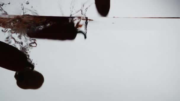 Silhouette de poivre tombant dans l'eau 