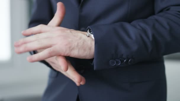 Uomo d'affari che gioca con le mani e controlla ora sul suo orologio . — Video Stock