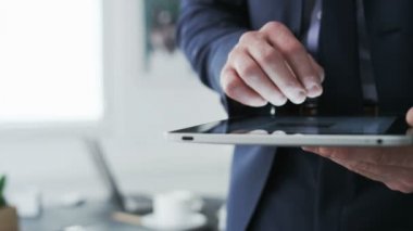 Bir tablet kullanırken işadamı el.