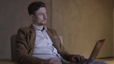 Bir koltukta oturan depresif iş adamı.