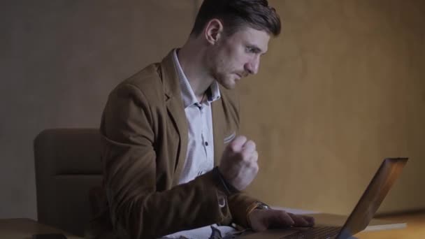 Бизнесмен с волнением смотрит на свой ноутбук . — стоковое видео