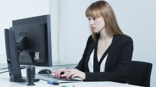 Ganska ung kvinna uttråkad medan du skriver på ett tangentbord — Stockvideo