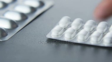 Adam beyaz tabletler masanın üzerine koyarak