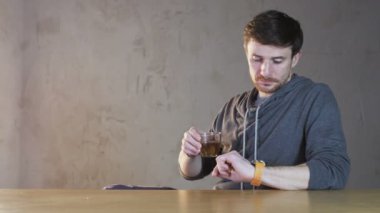 Genç adam denetler saat izle ve yaprakları