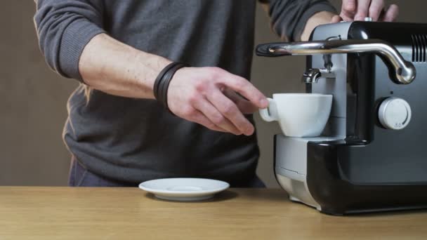 Un hombre saca una taza de la máquina de café — Vídeo de stock