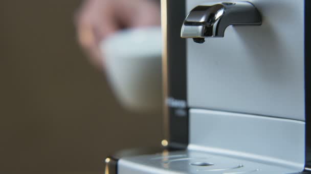 Joven pone una taza en la máquina de café — Vídeo de stock