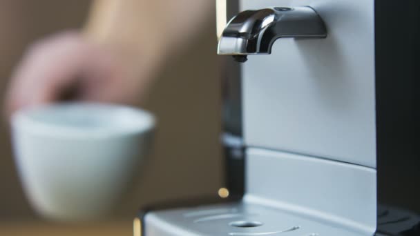 Jovem coloca uma xícara na máquina de café — Vídeo de Stock