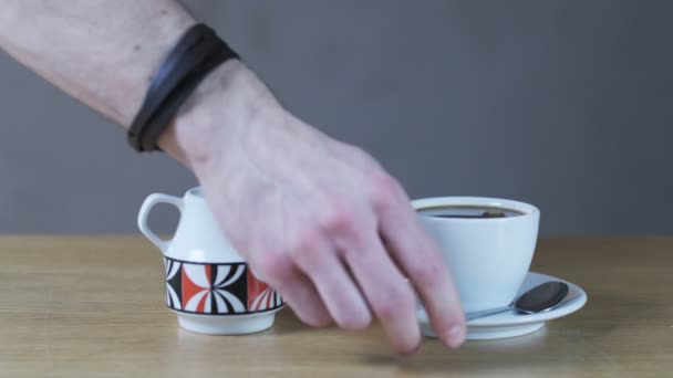 Um homem agitando em uma taça com uma colher de chá — Vídeo de Stock