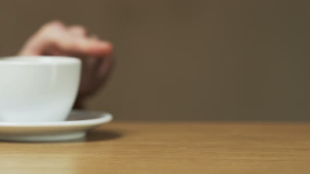 Bir adam bir fincan ile fincan tabağı iter — Stok video