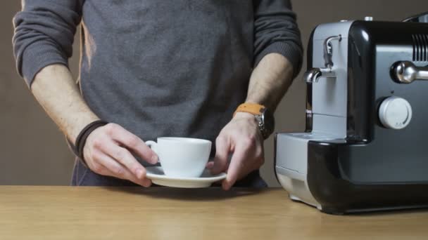 Человек кладет чашку в кофеварку — стоковое видео