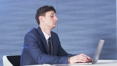 İşadamı bir bilgisayarla çalışırken yorgun