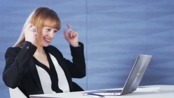 Hübsche junge Frau glücklich, während sie einen Computer benutzt — Stockvideo