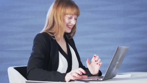 Hübsche junge Frau glücklich, während sie einen Computer benutzt — Stockvideo