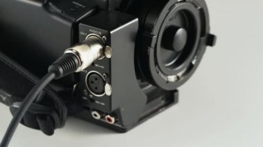 Bir Video kamera siyah kablosunu prizden kadın. Kablo bağlantısı. Yakın çekim. Kırmızı Epic vurdu