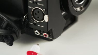 Kadın kırmızı ve beyaz kablolar fotoğraf makinesi tıkalı. Kablo bağlantısı. Yakın çekim. Kırmızı Epic vurdu