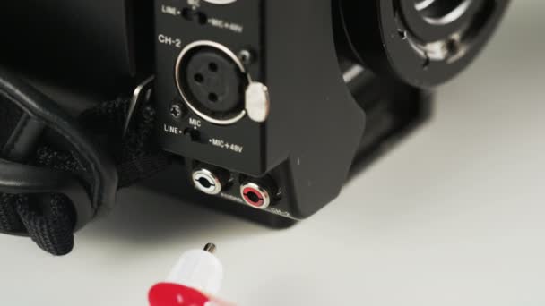 女人把红色和白色的电缆插入相机 电缆堵塞 拍摄红色史诗 — 图库视频影像