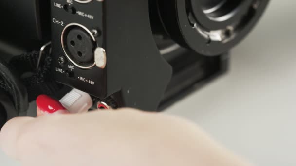 Vrouw Opnieuw Inpluggen Een Witte Kabel Aan Een Video Camera — Stockvideo