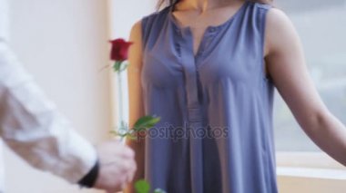 Bir adam bir kadınla bir kırmızı gül verir. Burası kokuyor. Bir adam bir çiçek veriyor. Yakın çekim. Kırmızı Epic vurdu