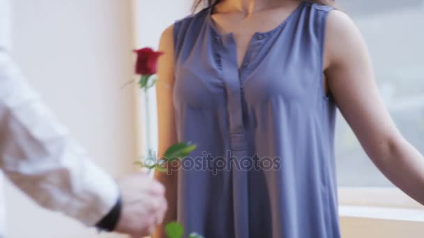 男性は女性に赤いバラを与えます 彼女はそれをにおいがします 花を与えます クローズ アップ 赤の叙事詩のショット — ストック動画