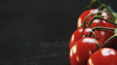Sağdan sola kaydırılması domates. Siyah bir zemin üzerine kırmızı meyve. Yakın çekim. Kırmızı Epic vurdu