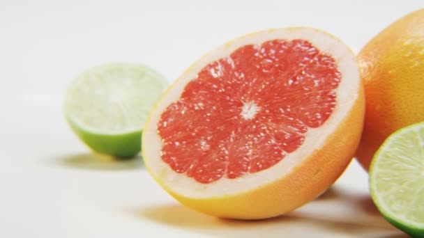 白色背景的柑橘类水果 红色葡萄柚和石灰 在慢动作中拍摄红色史诗 — 图库视频影像