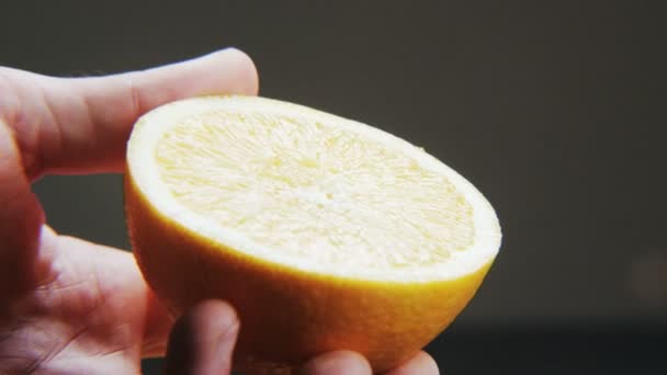Mezza Arancione Sfondo Nero Agrumi Nelle Mani Uomo Primo Piano — Video Stock