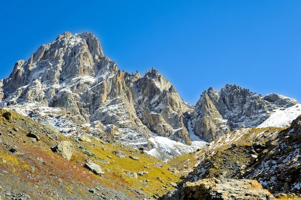 Montagne del Caucaso, villaggio Juta. collina verde, cielo blu, montagna da pietre e cima innevata Chaukhebi in estate . — Foto Stock