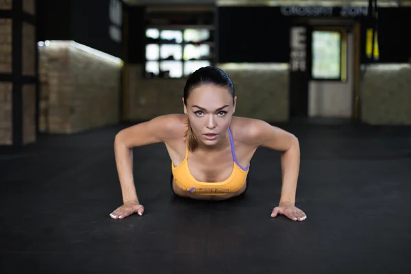 Mujer empujada desde el suelo en el gimnasio — Foto de Stock