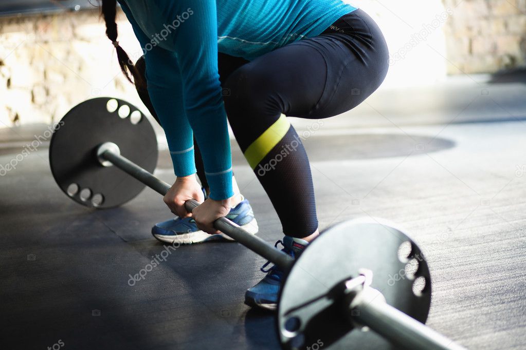 Muscular woman in a gym doing deadlift