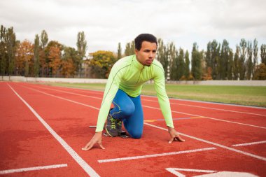Sportif delikanlı koşu parkurundakilerden çalışmaya hazır. Büyük güzel modern Stadı nda düzgün biçimli insanların uygun