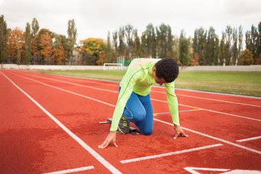 Sportif delikanlı koşu parkurundakilerden çalışmaya hazır. Büyük güzel modern Stadı nda düzgün biçimli insanların uygun