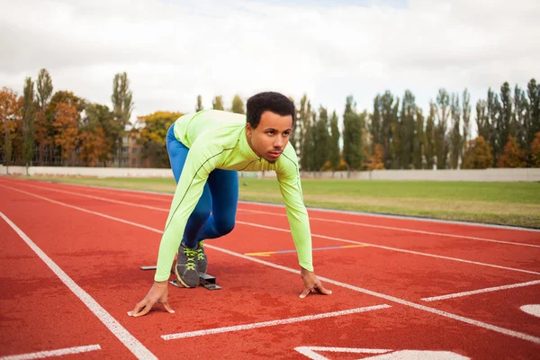 Young sporty man are ready to run on racetrack. Fit well formed people  at large nice modern stadium — Stock Photo, Image