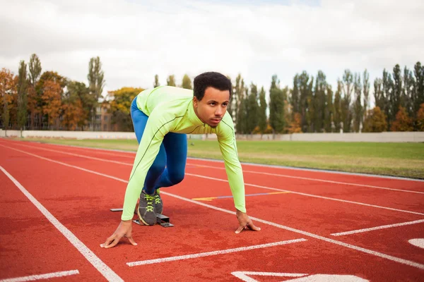 Un jeune sportif est prêt à courir sur un circuit. S'adapter aux personnes bien formées au grand stade moderne agréable — Photo