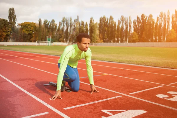 Young sporty man are ready to run on racetrack. Fit well formed people at large nice modern stadium — Stock Photo, Image