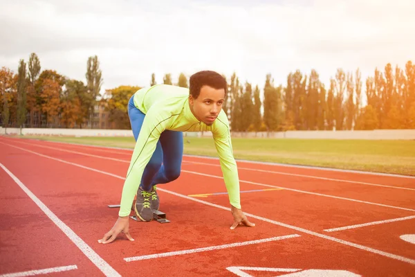 Young sporty man are ready to run on racetrack. Fit well formed people at large nice modern stadium — Stock Photo, Image