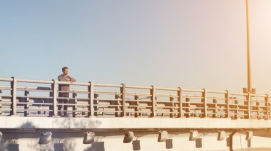 Köprüde duran ve doğanın keyfini adam